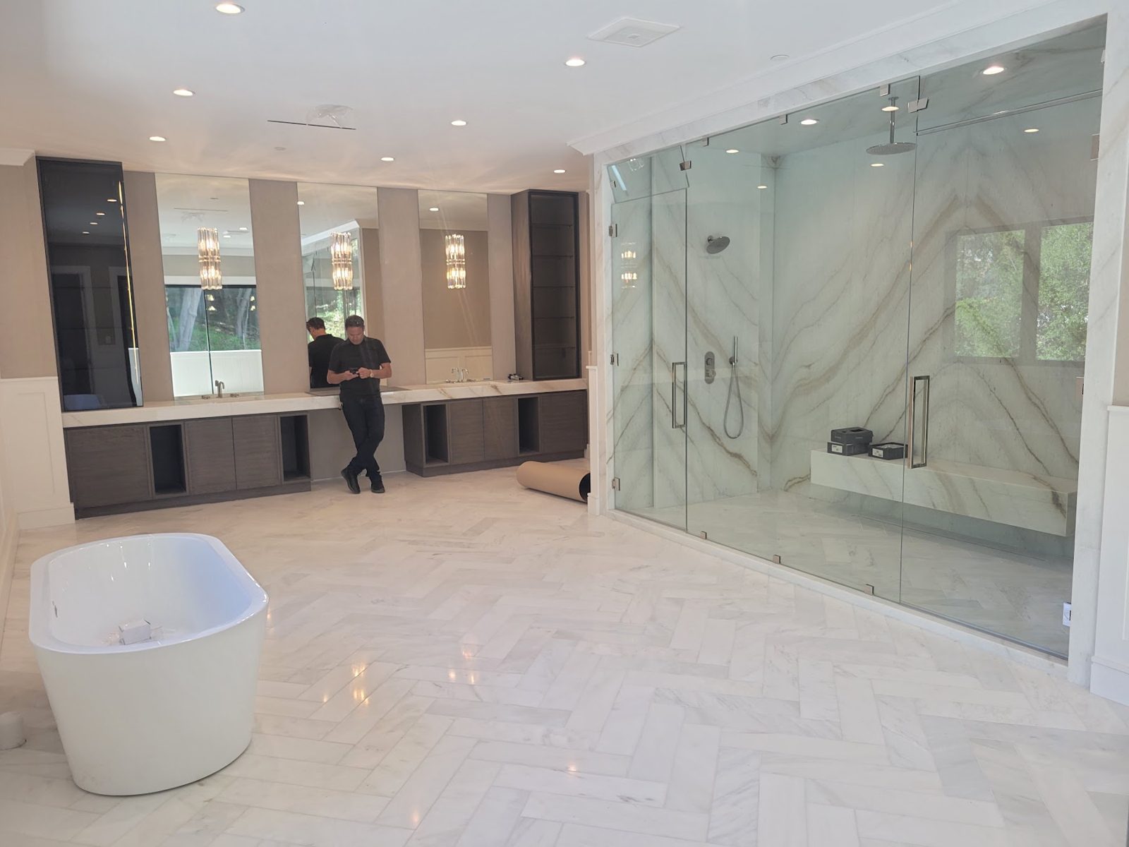 Remodeled bathroom with a freestanding tub and marble slab walls