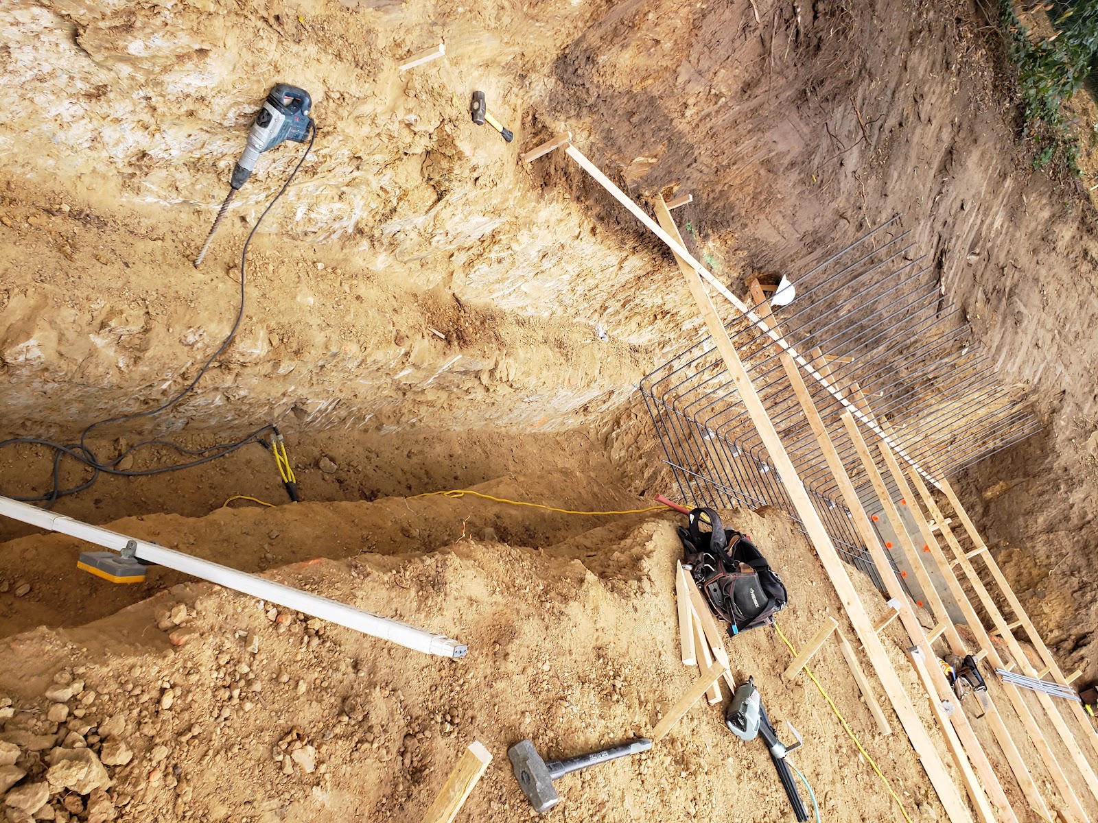 Deep hillside trench cut for caissons and drainage — Boca de Canon custom home build in Brentwood, Los Angeles