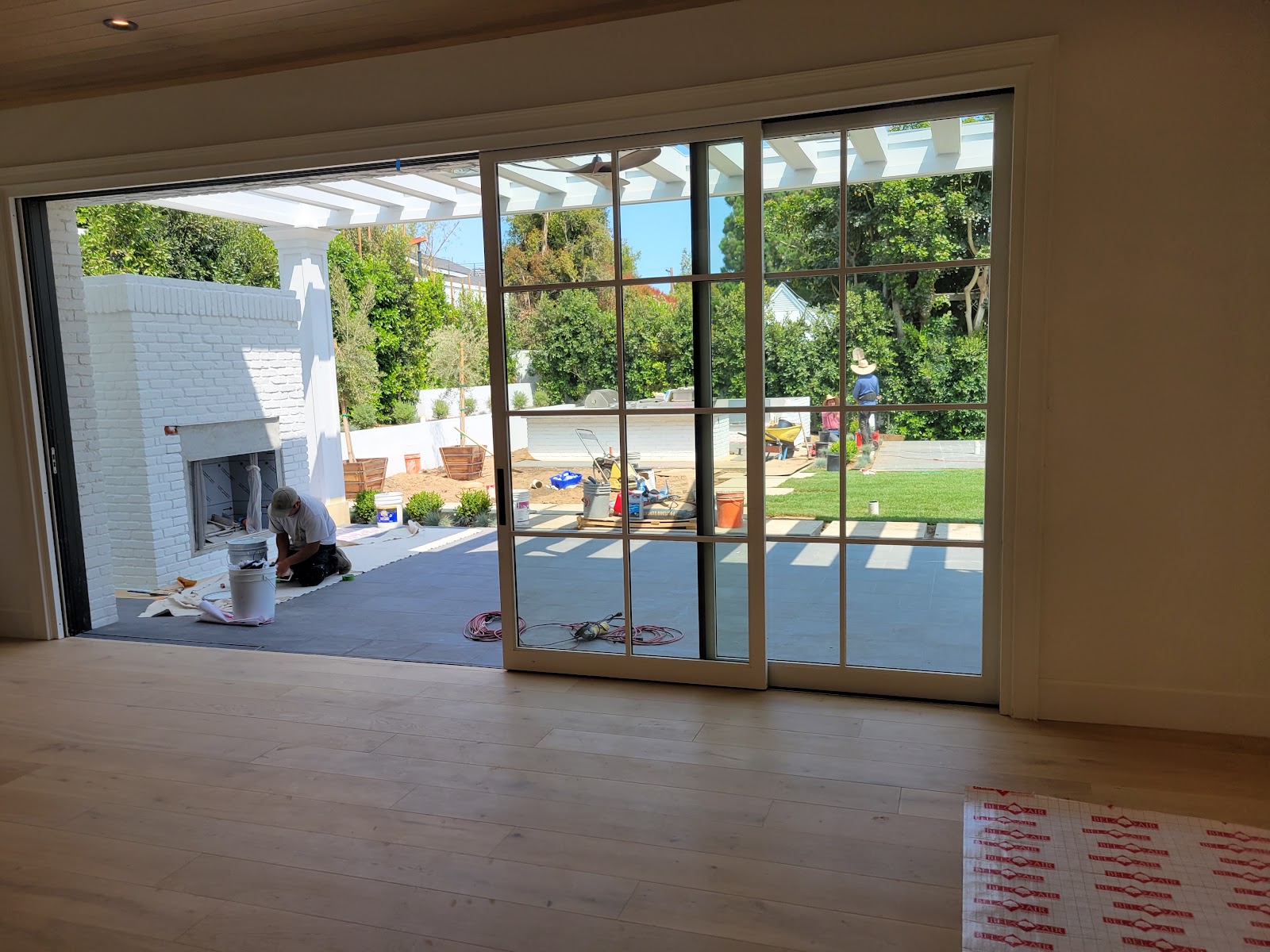 Sliding glass wall opening the living room to the yard — Boca de Canon custom home build in Brentwood, Los Angeles